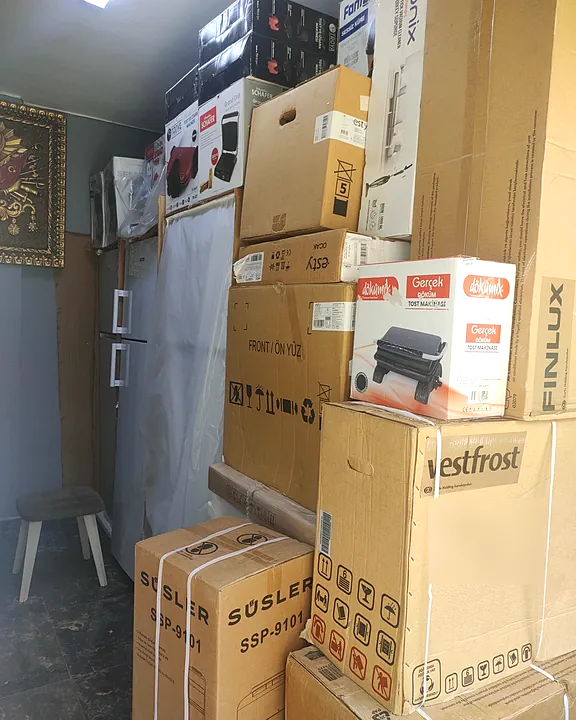 UM SPOT deposunda kutulu küçük ev aletleri — tost makinesi, dik süpürge ve mutfak cihazları